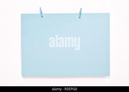 Carte papier sur vêtements peg sur fond blanc Banque D'Images