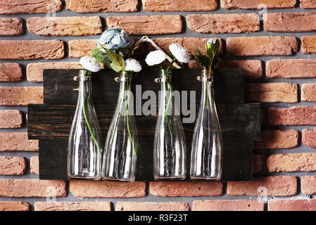 Décoration d'intérieur avec des bouteilles sur mur de brique avec des fleurs. Grand pour mariage Banque D'Images