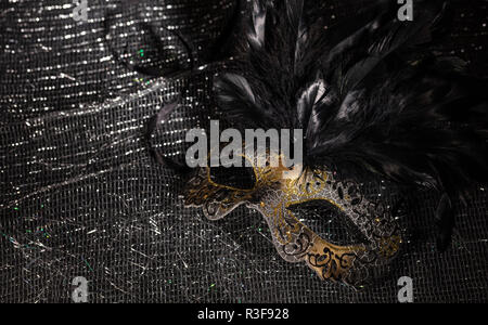 Le carnaval. Masque de Venise, avec des plumes d'or sur fond noir, brillant, copy space Banque D'Images