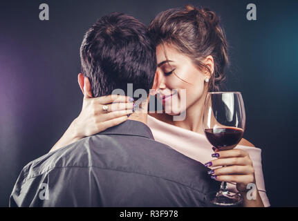 Couples célébrant la Saint Valentin de boire du vin rouge sur fond noir Banque D'Images