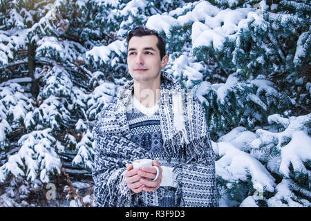 Jeune femme est titulaire d'tasse de café avec de la guimauve dans la forêt d'hiver Banque D'Images