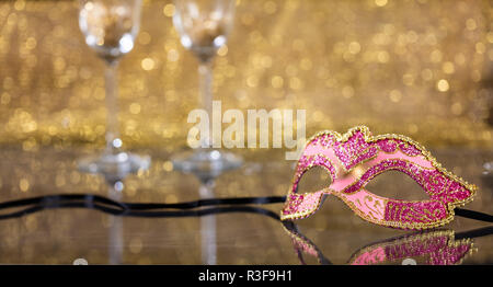 Carnival party. Masque de Venise et verres de champagne sur fond flou d'or, réflexions, copy space Banque D'Images