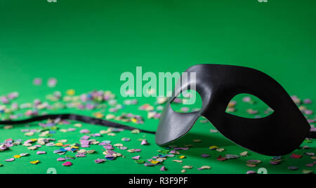 Carnival party. Masque de Venise et les confettis sur fond vert, copy space Banque D'Images