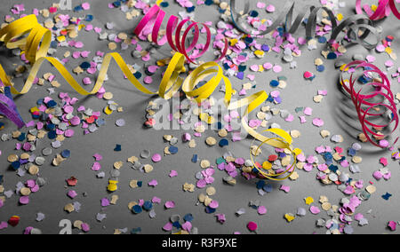 Carnaval ou fête d'anniversaire. Confettis et Serpentins sur fond gris Banque D'Images