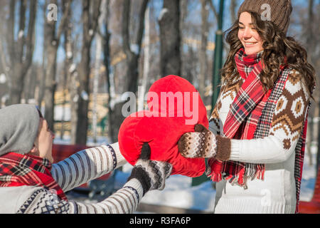 L'homme donne à sa petite amie un coussin coeur pour la Saint-Valentin Banque D'Images