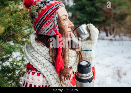 Jeune femme est titulaire d'un thermos de thé et des boissons en forêt d'automne Banque D'Images