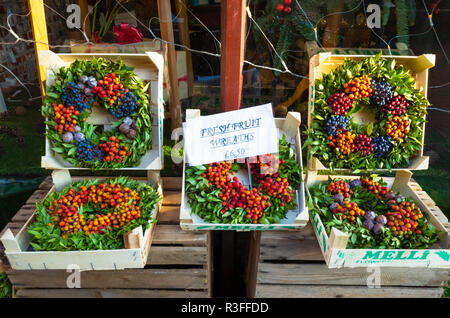 Des couronnes de Noël saisonnières de fruits en vente à l'extérieur d'une boutique de fleuristes en novembre 2018 prix Banque D'Images