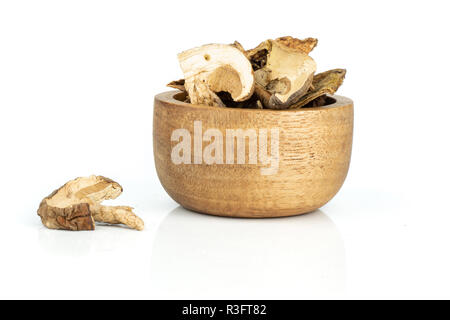 Beaucoup de tranches de champignons bruns secs boletus edulis variété avec bol en bois isolé sur fond blanc Banque D'Images