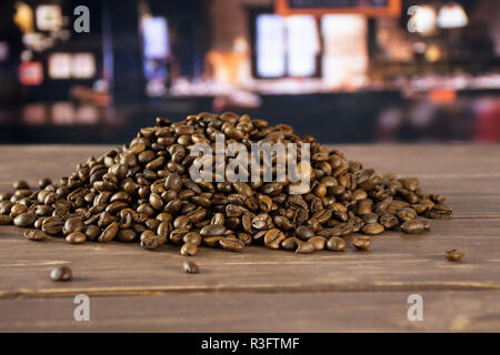 Ensemble de grains de café brun foncé variété arabica doux avec restaurant en arrière-plan Banque D'Images