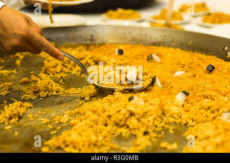 Grande paella valencienne étant servi par serveur Banque D'Images