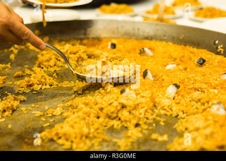 Grande paella valencienne étant servi par serveur Banque D'Images