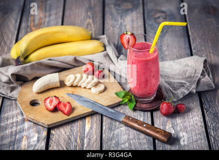 Smoothie aux fraises et bananes sur fond de bois Banque D'Images