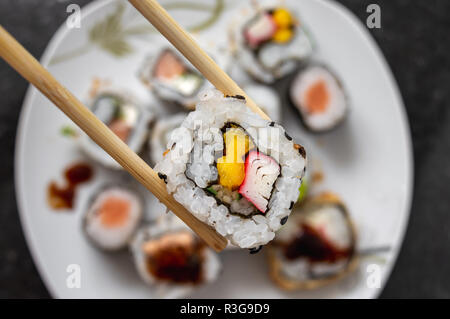 Attrapant une california roll nourriture japonaise avec chopstick - Vue de dessus Banque D'Images