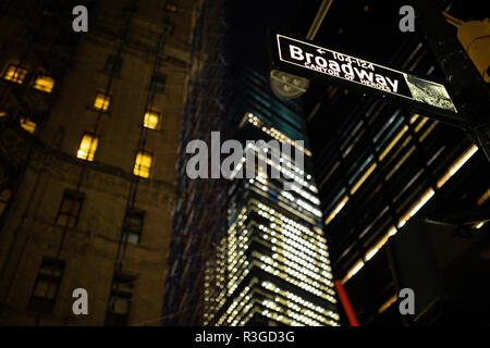 (Selective focus) signe de Broadway éclairés la nuit à Manhattan, New York. Arrière-plan flou sur la construction. Banque D'Images