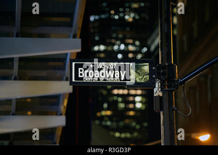 (Selective focus) signe de Broadway éclairés la nuit à Manhattan, New York. Arrière-plan flou sur la construction. Banque D'Images