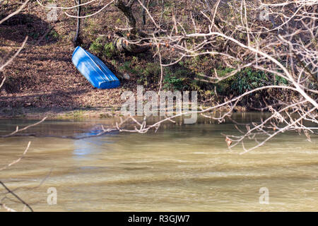 Petit bateau bleu metal repose à l'envers sur la rive occidentale de la rivière Yadkin dans Wilkes Couny, Caroline du Nord. Banque D'Images