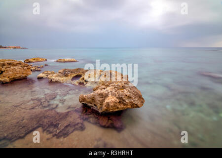 Une longue exposition à Antalya, avec brown rocky mer et temps nuageux. 4 minutes de temps Longexposure Banque D'Images