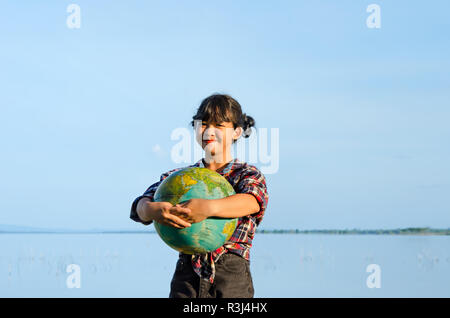 Vue avant du asian girl hands holding a globe balle dans la nature . concept sauver le monde Banque D'Images