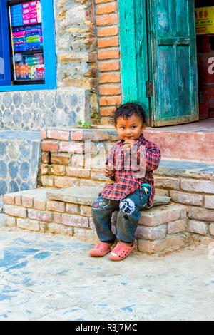 Garçon assis sur l'escalier népalais, Bandipur, Tanahun district, Népal Banque D'Images