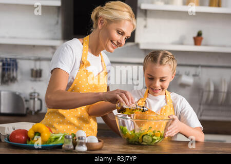 Heureux grand-mère et sa petite-fille dans la cuisine tabliers ensemble Banque D'Images