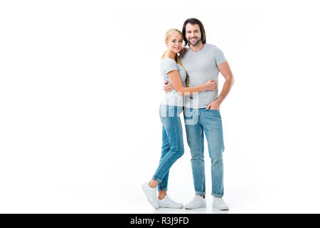 Beautiful couple portant des jeans et T-shirt gris hugging chaque autres isolated on white Banque D'Images