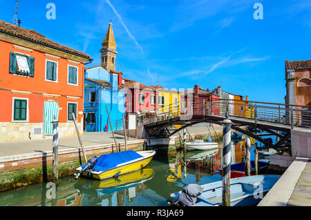 Maisons colorées près de canal sur l'île de Burano, Venise, Italie. Burano est célèbre pour sa dentelle et travail maisons peintes de couleurs vives. Se penchant campanile de San Ma Banque D'Images