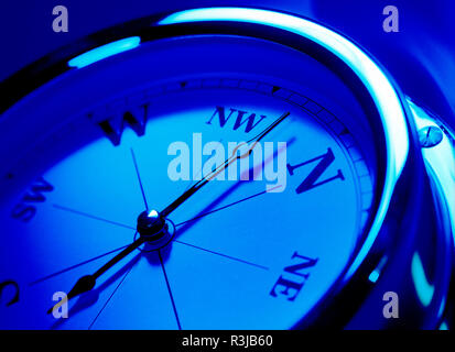 Gros plan d'une boussole avec un effet ton bleu, pointant au nord, nord-ouest. Banque D'Images