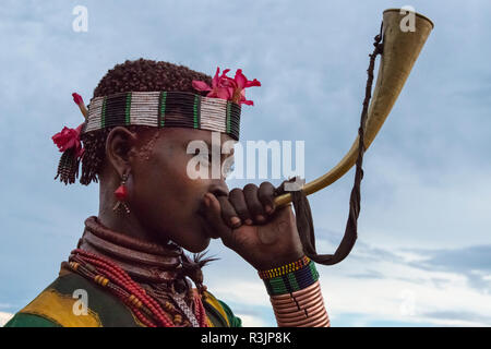 Tribu Hamar, woman blowing corne à Hamar, village du sud Omo, Ethiopie Banque D'Images