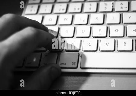 Le noir et blanc main sur clavier Mac Apple Banque D'Images