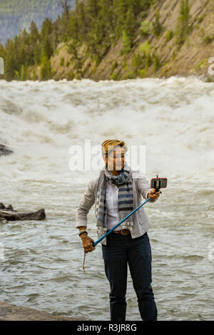 BANFF, ALBERTA, CANADA - Juin 2018 : visiteur à l'aide d'un bâton selfies pour prendre une photo à l'avant selfies River Falls à Banff. Banque D'Images