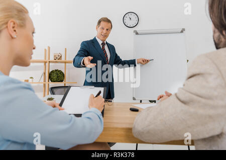 Businessman pointing at conseil blanc tandis que la signature de deux contrats au presse-papiers Banque D'Images