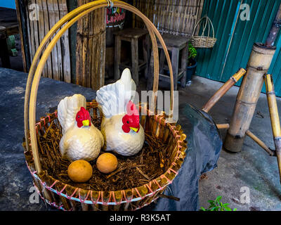 Un village dans le Nord de la Thaïlande avec un faux poulet dans un panier avec des œufs sur l'affichage. Banque D'Images