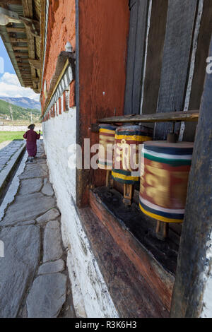 Le Bhoutan. Un dévot circumambulates Jambay Lhakhang temple dans la région de Bumthang. Banque D'Images