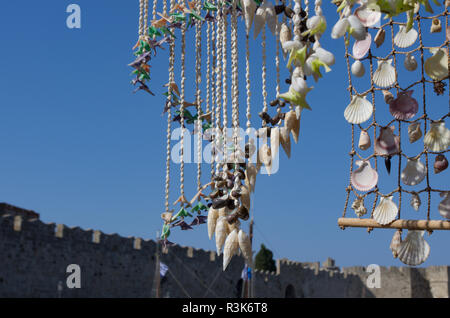 Wind Chimes méditerranéenne faite de coquillages sur le fond de la forteresse mur et ciel bleu Banque D'Images