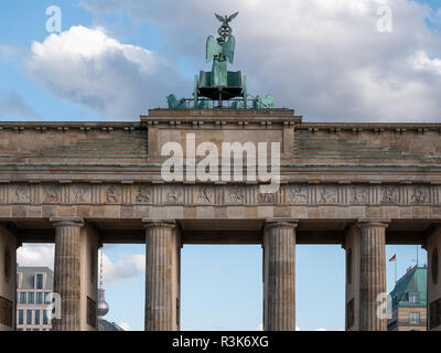 Le quadrige de la porte de Brandebourg contre un bleu ciel nuageux avec en arrière-plan, la tour de télévision de Berlin, Allemagne Banque D'Images