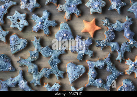Noël arrière-plan, mise à plat et un flocon et star des biscuits avec du sucre saupoudré sur bois en gris, bleu et orange Banque D'Images