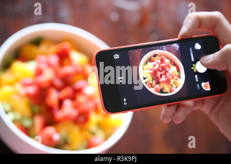 Photoshooting avec un smartphone à partir de l'idée de dessert : salade de fruits délicieux avec des choix de fruits et de baies Banque D'Images