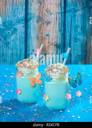 Licorne bleue du chocolat chaud avec de la crème fouettée, le sucre et arrose Banque D'Images