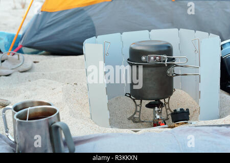 Cuisine touristiques, brûleur gaz traveler, pique-nique sur la plage de sable Banque D'Images