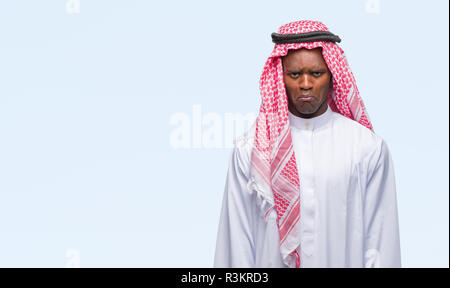 Jeune arabe african man wearing keffieh traditionnel isolé sur fond d'arrière-plan et l'inquiétude de la détresse, de pleurer en colère et peur. Triste expressi Banque D'Images