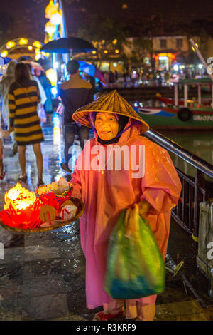 Vieille dame vendre flotteurs bougie, Hoi An. Tet Festival, Fête du Nouvel An, au Vietnam. Banque D'Images