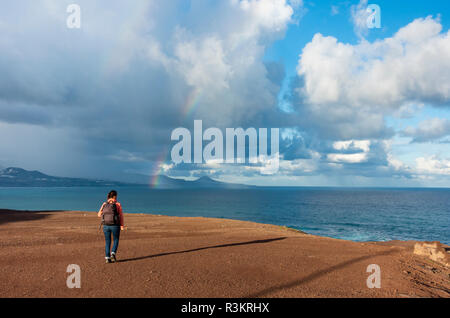 Las Palmas, Gran Canaria, Îles Canaries, Espagne. 23 novembre 2018. Météo : A female hiker donne vers un arc-en-ciel sur l'Océan Atlantique comme une pluie torrentielle, qui a balayé les îles Canaries au cours des 24 dernières heures, enfin efface Gran Canaria. Credit : ALAN DAWSON/Alamy Live News Banque D'Images