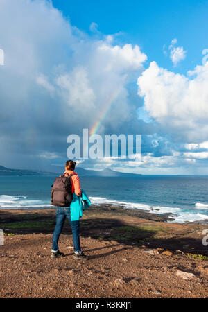 Las Palmas, Gran Canaria, Îles Canaries, Espagne. 23 novembre 2018. Météo : A female hiker donne vers un arc-en-ciel sur l'Océan Atlantique comme une pluie torrentielle, qui a balayé les îles Canaries au cours des 24 dernières heures, enfin efface Gran Canaria. Credit : ALAN DAWSON/Alamy Live News Banque D'Images