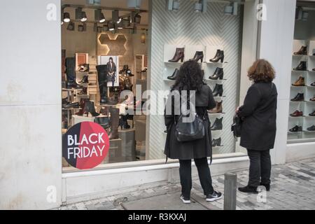 Athènes, Grèce. 23 Nov 2018. Les femmes sont considérées debout à côté de la vitrine avec le vendredi noir des réductions. Des milliers de personnes ont afflué au centre d'Athènes pour faire des achats, en raison de réductions Vendredi Noir. Credit : SOPA/Alamy Images Limited Live News Banque D'Images