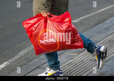 Sacs à provisions en plastique rouge; TK Maxx Black Friday Weekend Shoppers. Centre-ville saison de shopping de vacances, magasins de détail, magasins, les acheteurs de Noël, les achats de vente à prix réduit, Les dépenses de consommation des femmes pour le week-end du Vendredi fou sont considérées comme le plus grand événement de magasinage de l'année. Les détaillants du Royaume-Uni ont adopté le programme de soldes de style américain, et de nombreux clients ont été surpris par des remises à prix avantageux, par des achats de Noël et par le transport de plusieurs sacs, cadeaux, cadeaux et articles en vente. Banque D'Images