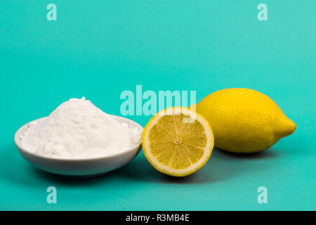 Le citron et le bicarbonate de soude dans une soucoupe isolé en néon bleu. Banque D'Images