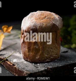 Libre d'un panettone, un doux italien typique pour la période de Noël, saupoudrée de sucre glace, sur une table en bois rustique Banque D'Images
