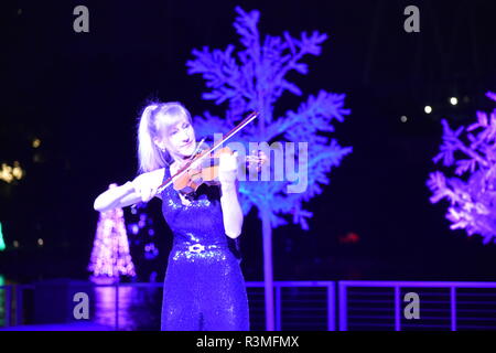 Orlando, Floride. 17 novembre, 2018. Femme artiste au violon sur fond de Noël dans la zone International Drive. Banque D'Images