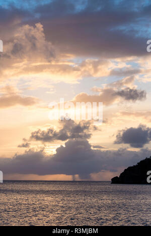 Royaume-uni, îles Vierges britanniques. Voilier et la pluie à l'horizon au coucher du soleil Banque D'Images