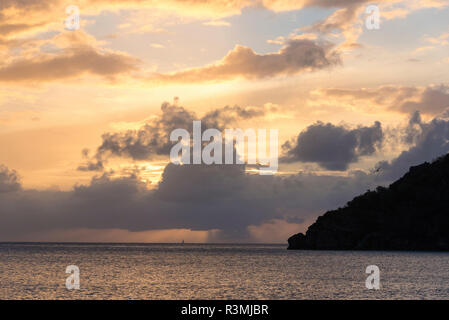 Royaume-uni, îles Vierges britanniques. Voilier et la pluie à l'horizon au coucher du soleil Banque D'Images